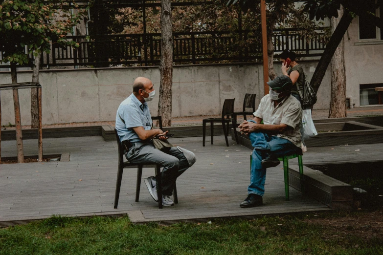 a man and another person sitting on a bench talking