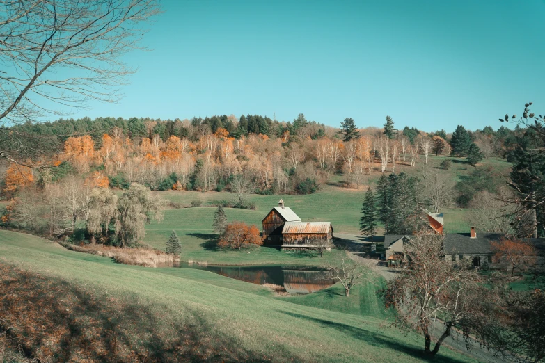 a farm surrounded by trees and some hills