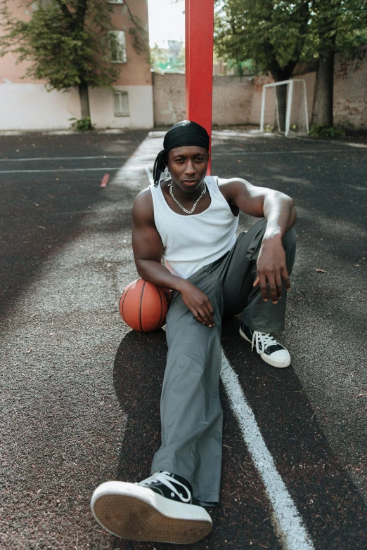 a young man sitting in the middle of a street