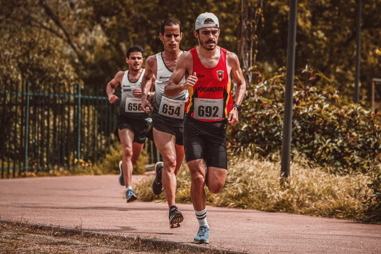 three runners running together down a paved pathway