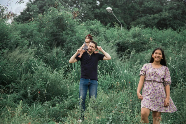 a couple is standing in tall grass holding a kite