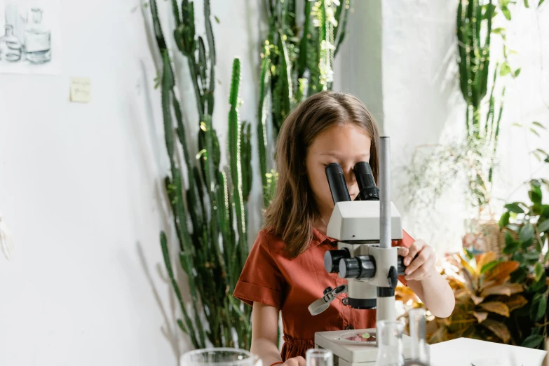 a woman is looking through a microscope