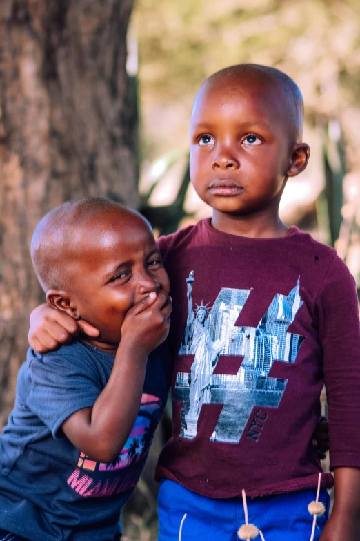 two children are standing near one another and staring up