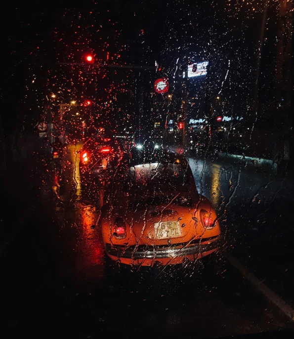 a car driving through the rain at night