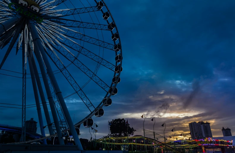 a dark sky and a ferris wheel in a park