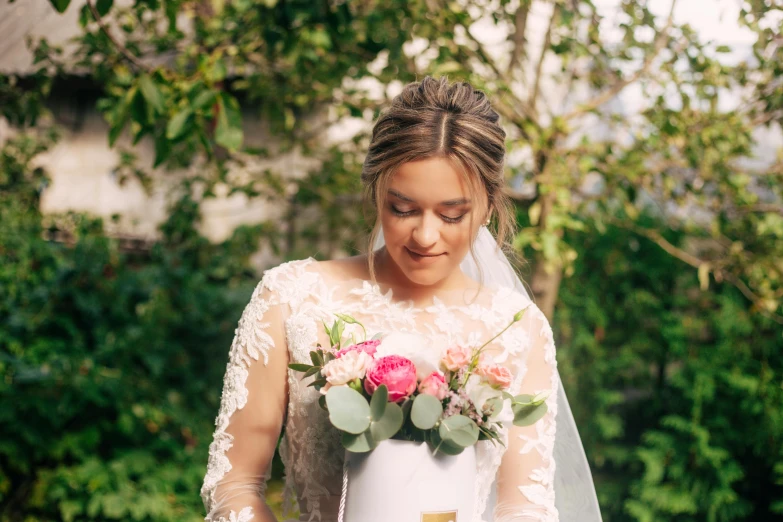 a woman wearing a veil and holding onto a bouquet of flowers