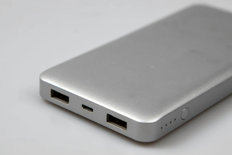 a silver and black portable power bank on a white surface