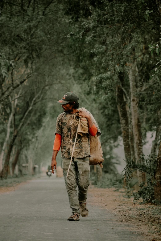 a man is walking through a trail carrying a backpack