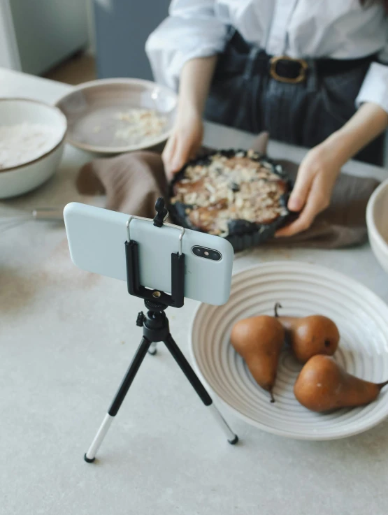 a person in a kitchen using a camera to take food