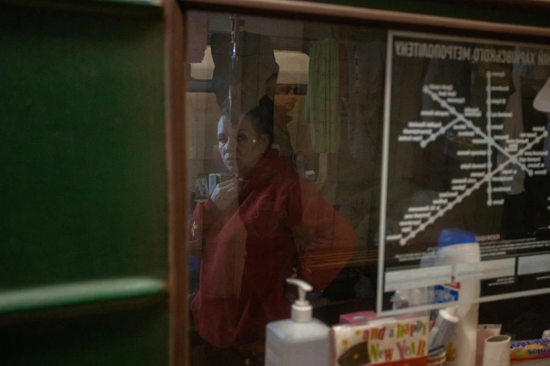 reflection in the window of a man with a hat