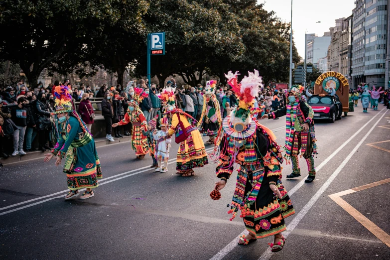 a street with people in costume and some cars