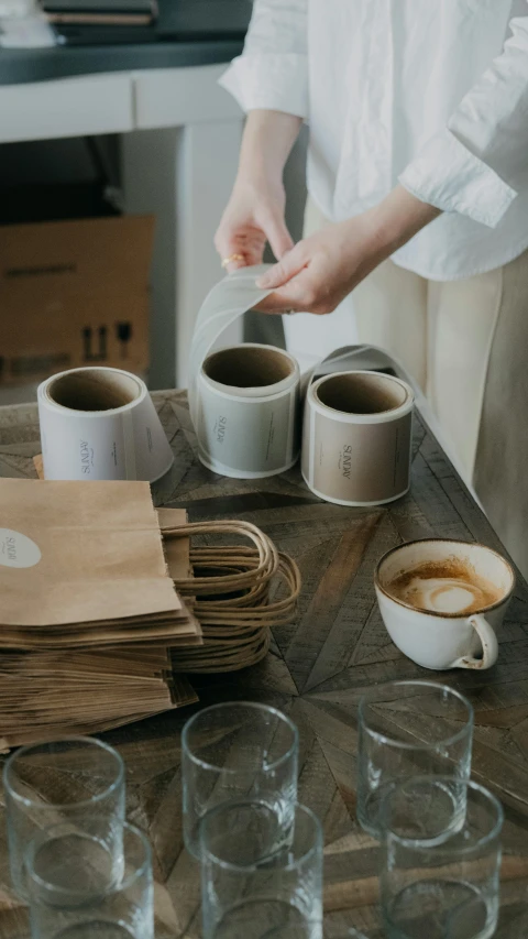 the person is pouring water into glass cups