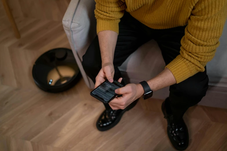 a man is sitting and using his phone