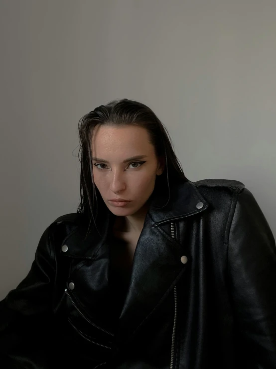 a woman in a black jacket wearing a leather jacket