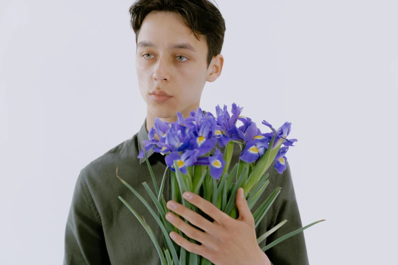 the person is holding a bunch of flowers and posing for a picture