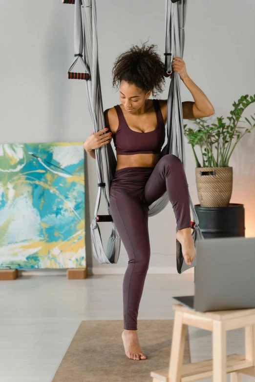 a person in a gym wear is hanging on a hammock