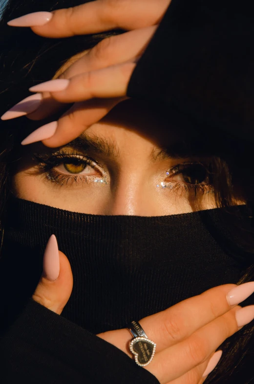 a woman covering her face with the black hood