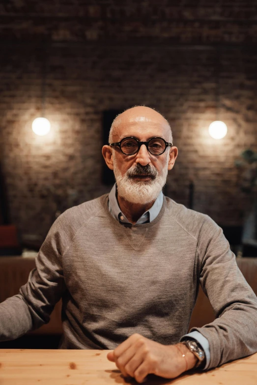 a man sits in front of a table wearing glasses