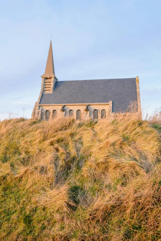 an old church with its steeple perched on a hill