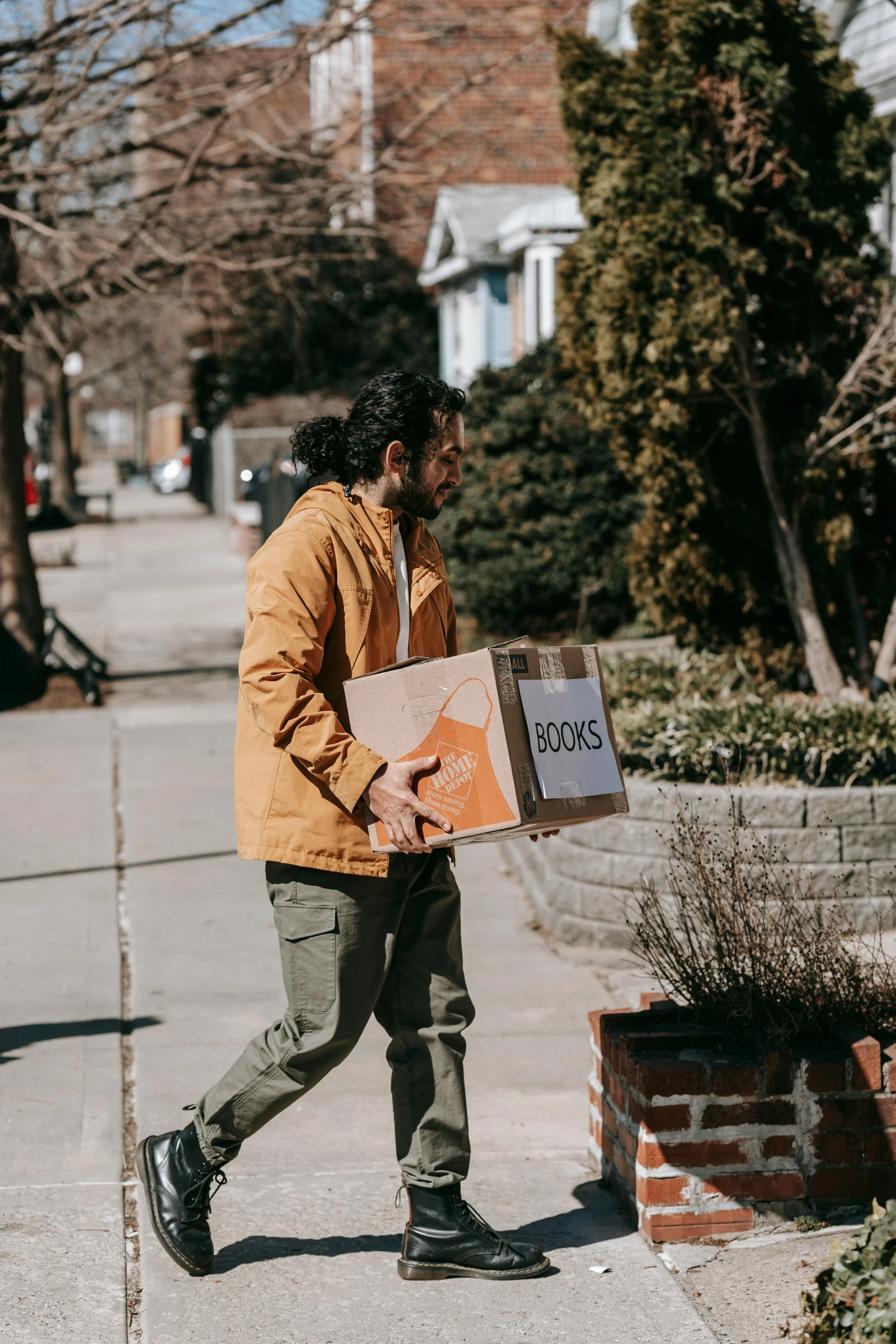 a man is walking on a sidewalk with a large package