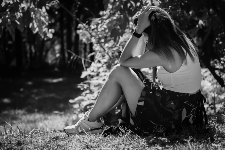 a young woman sitting in the grass wearing heels