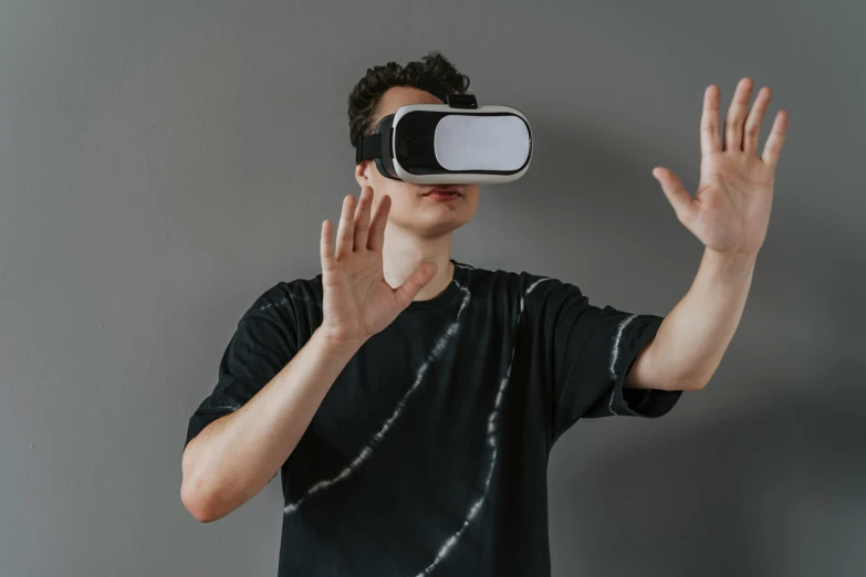 the man wearing a virtual device is pressing up his hands