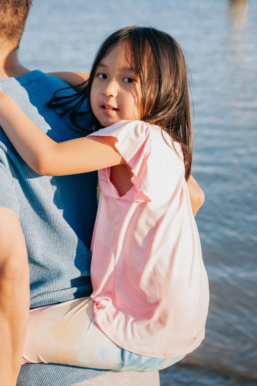 a woman is emcing her child by the ocean