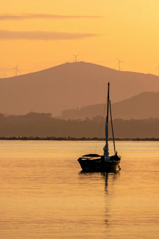 a boat floating in the water at sunset