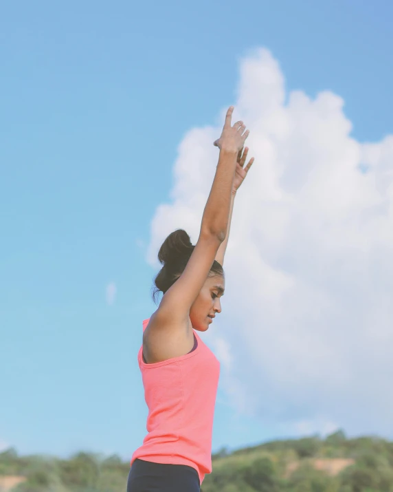 a woman in pink top and black shorts preparing to throw frisbee