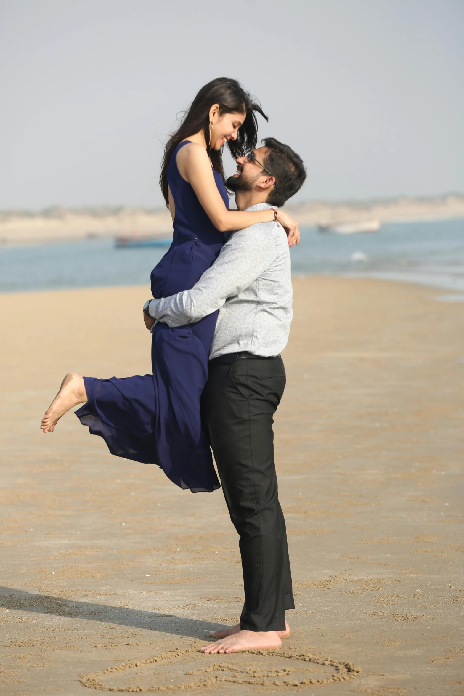 a man holding the shoulders of a woman on the beach