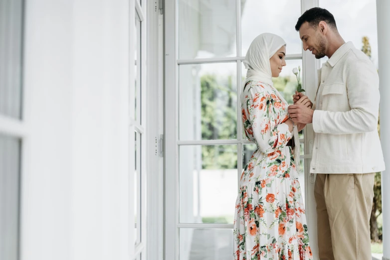 a man standing next to a woman holding a flower