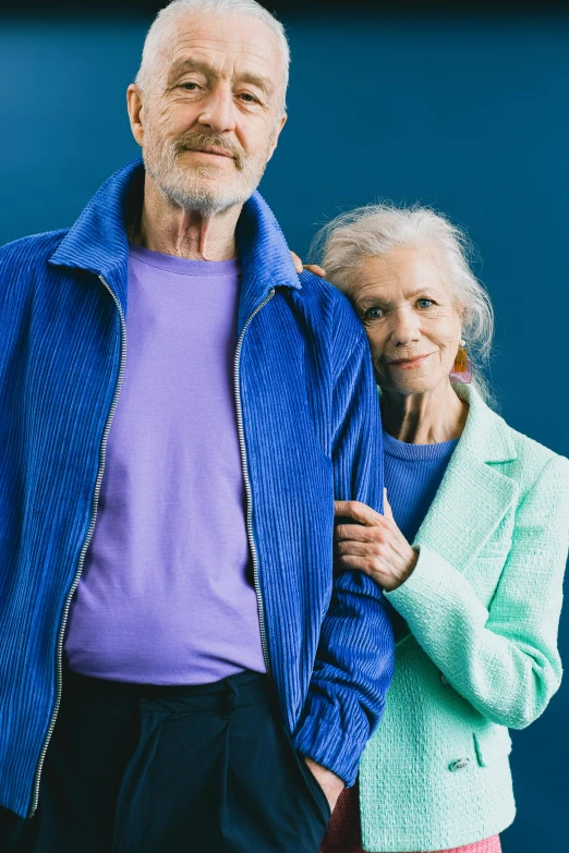 an older man and woman pose for the camera