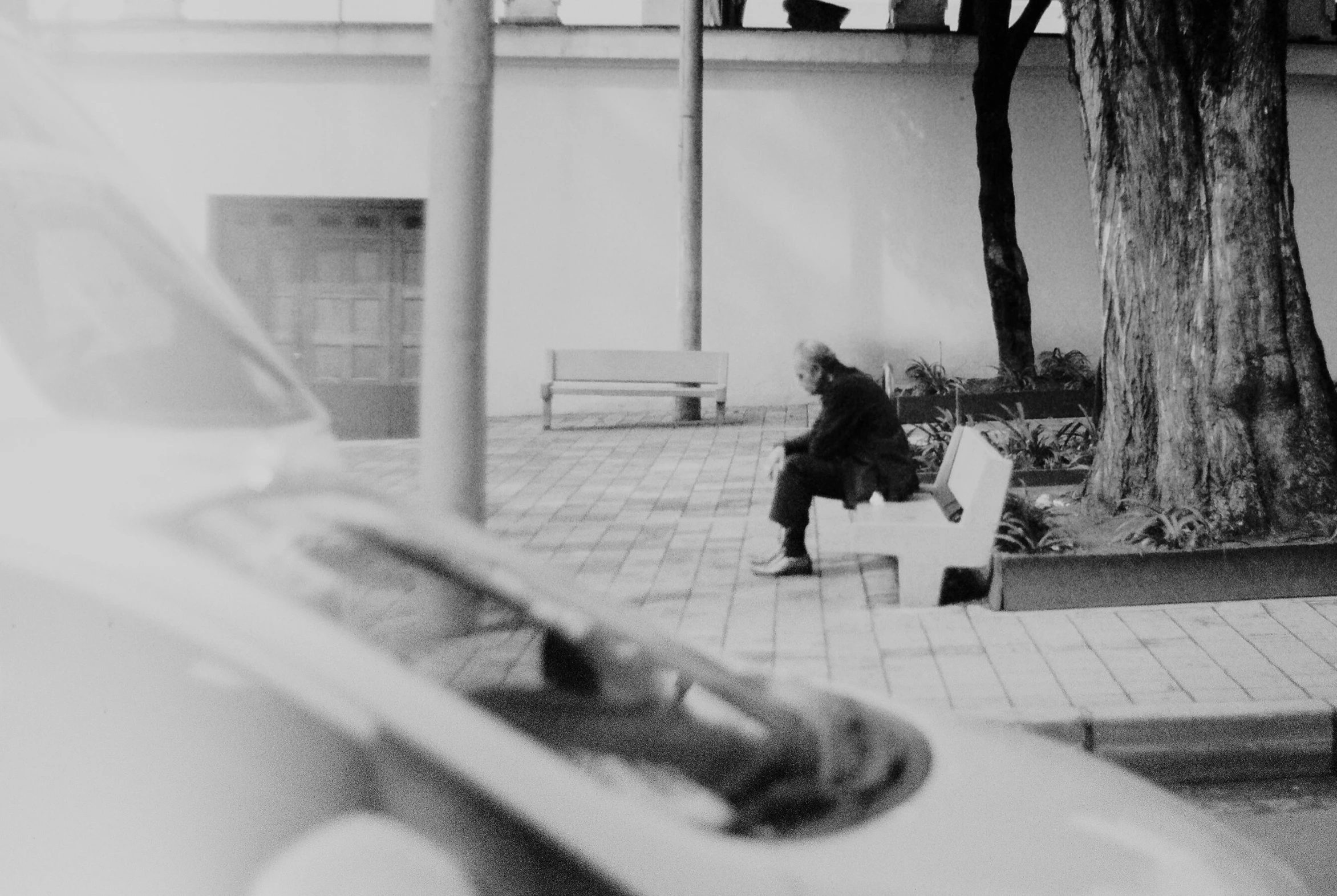 black and white image of a person sitting on a bench