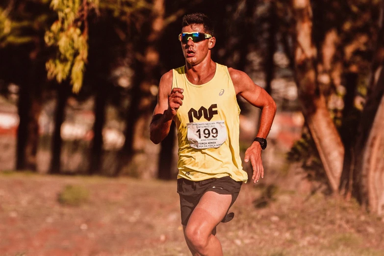 man running in yellow shirt near trees