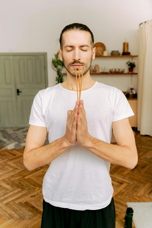 a man standing on a wood floor in prayer