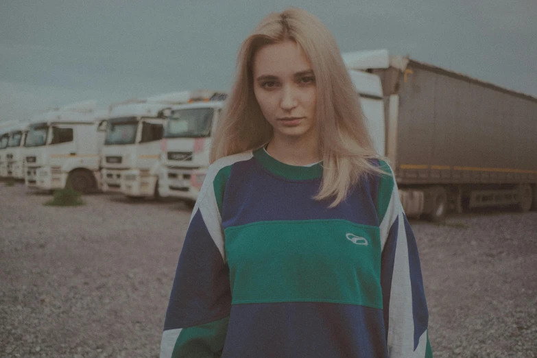 a girl in front of several trucks with a sad look on her face