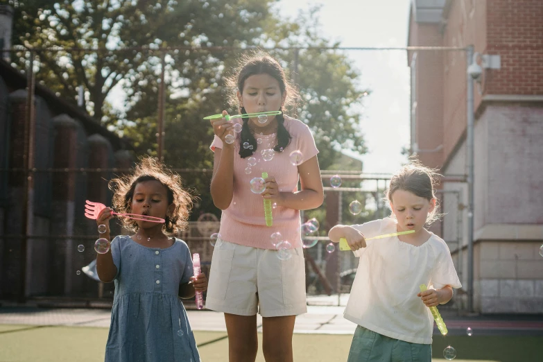 a girl and two other children standing on a tennis court