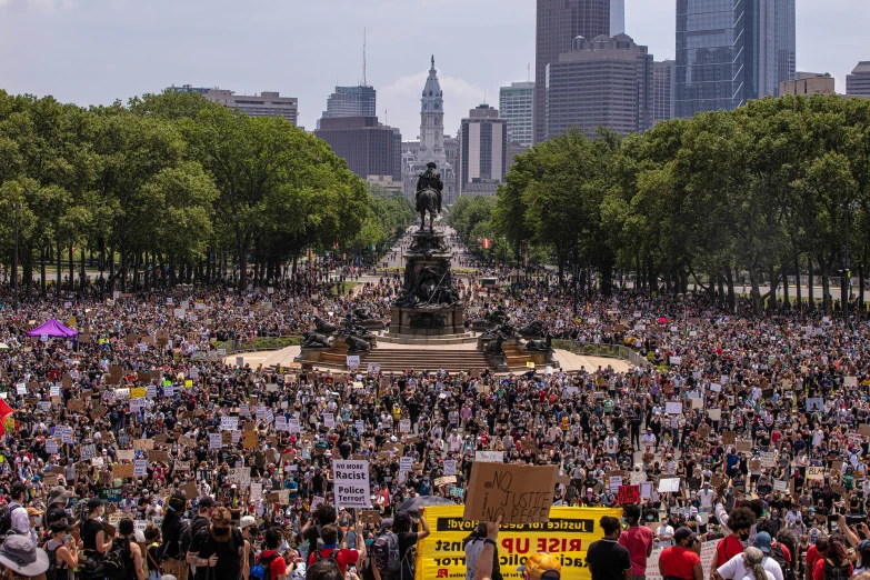 a large group of protesters gather on the grass to protest