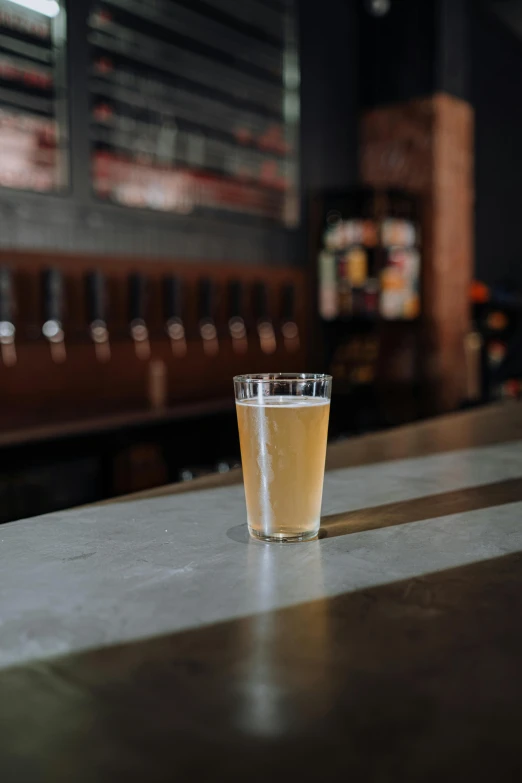 a glass of beer on top of a bar