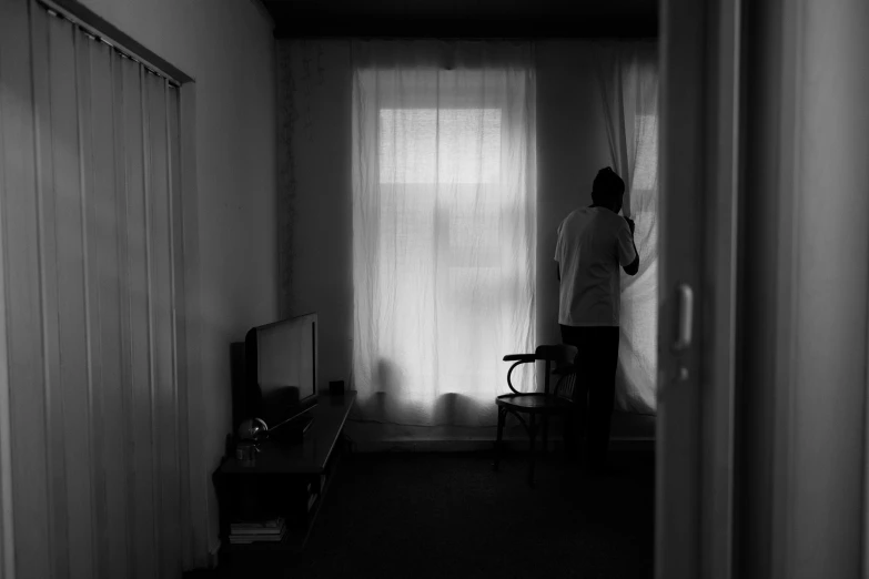 black and white pograph of someone standing in their home