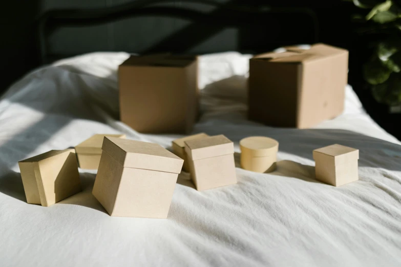three small boxes with some are on top of a bed