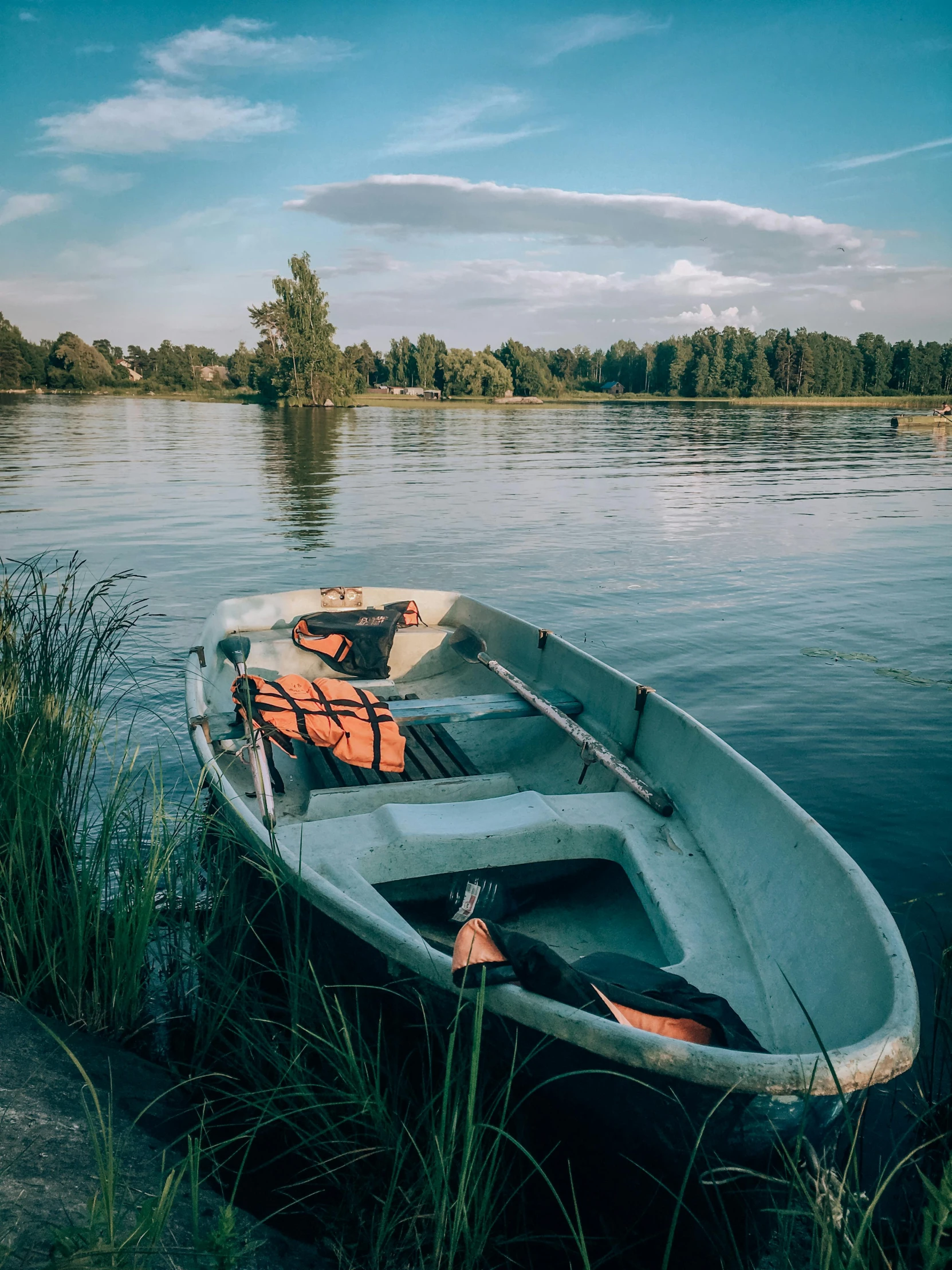 a boat sitting on the shore near some water