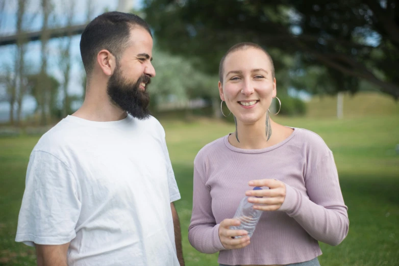 a man and woman standing in a park together