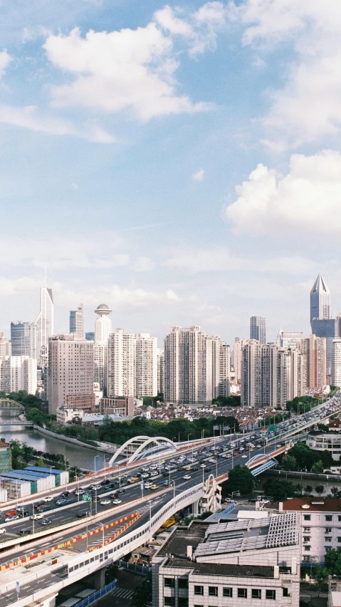 a bridge with traffic driving over it with lots of tall buildings in the background