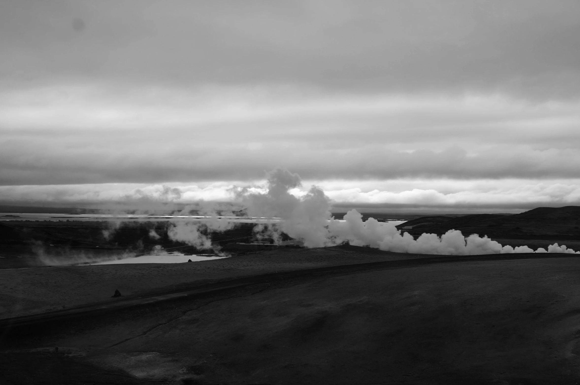 a black and white image of a large geyser coming out from the ground