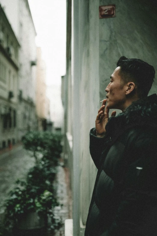 a man standing next to a building in the rain