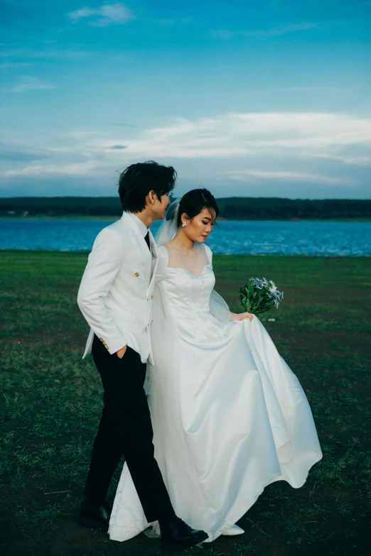 a man in a tuxedo and a woman wearing a wedding dress walking together