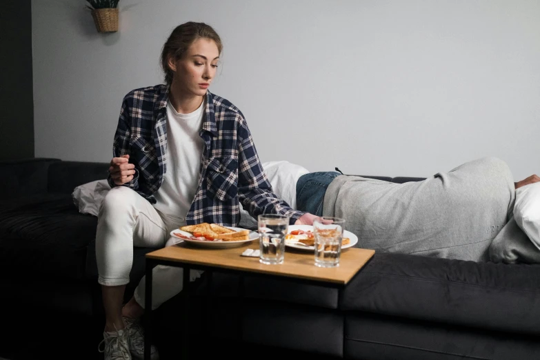 a woman is sitting on a sofa eating some food