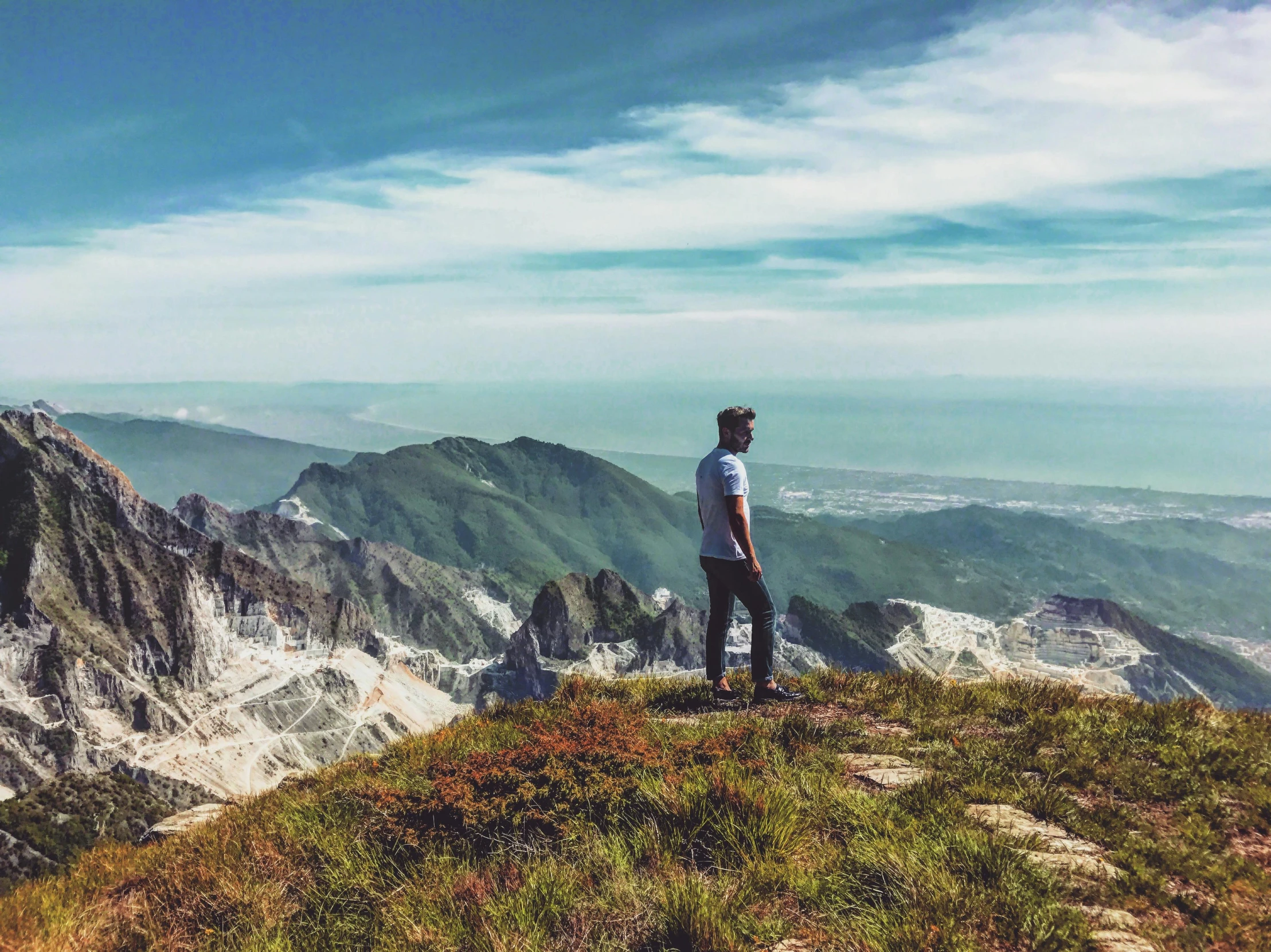 man standing on the peak watching a valley below