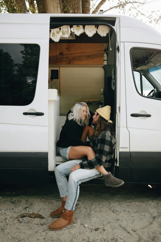 two people sitting in the back of a truck